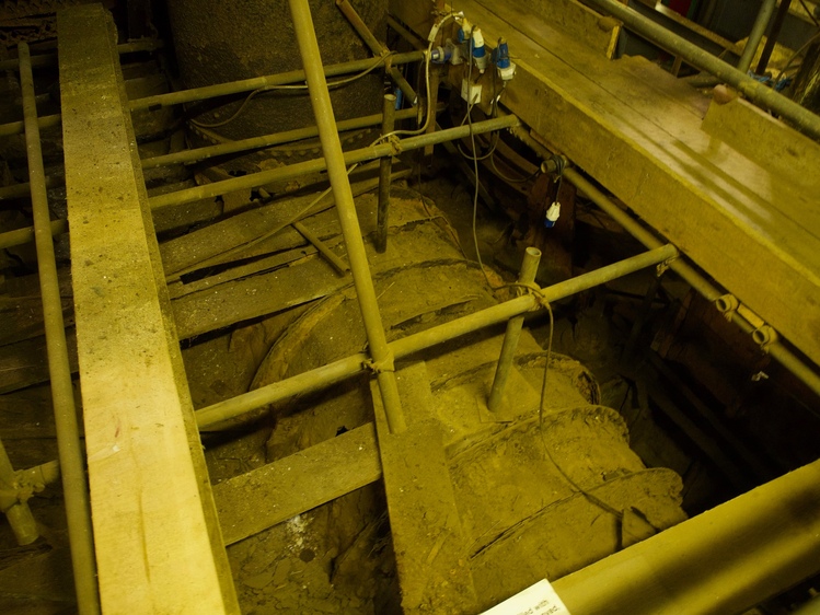 The top of a large pipe embedded in the ground. The image has a strong yellow tinge.