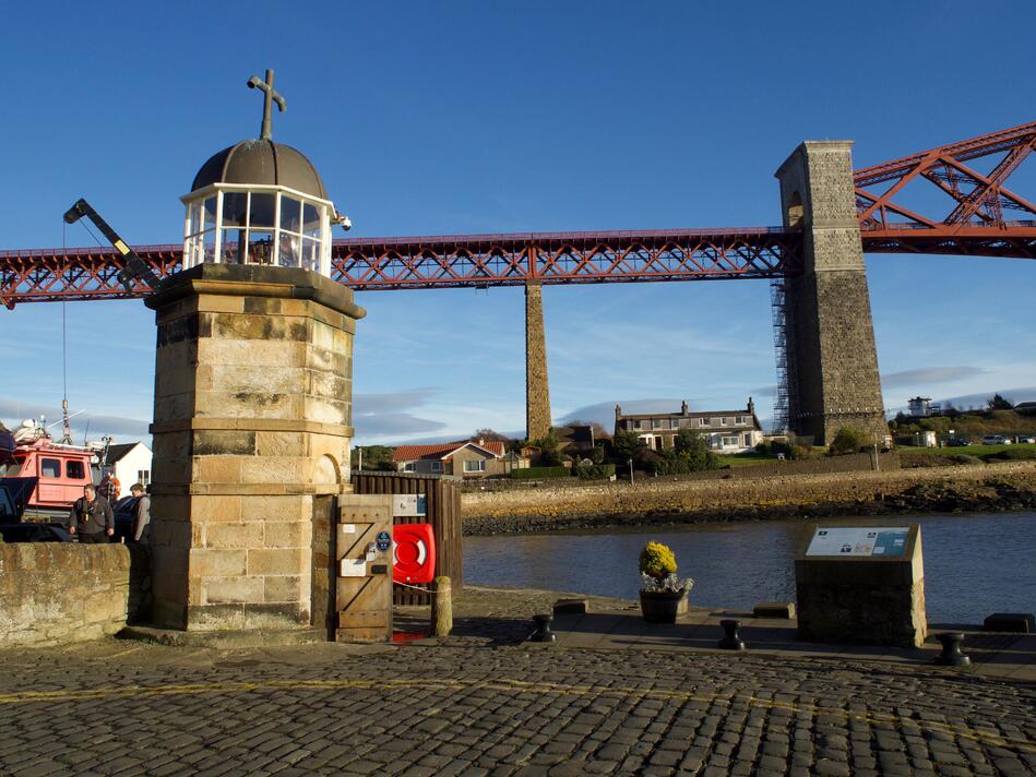 Another photo with the lighthouse in the foreground, and the bridge running parallel to the horizon in the background.